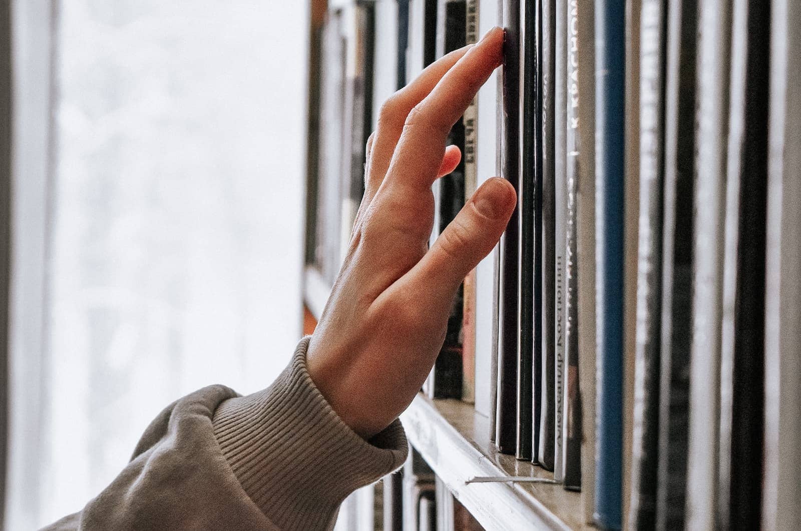 Person touching history books in library, archive